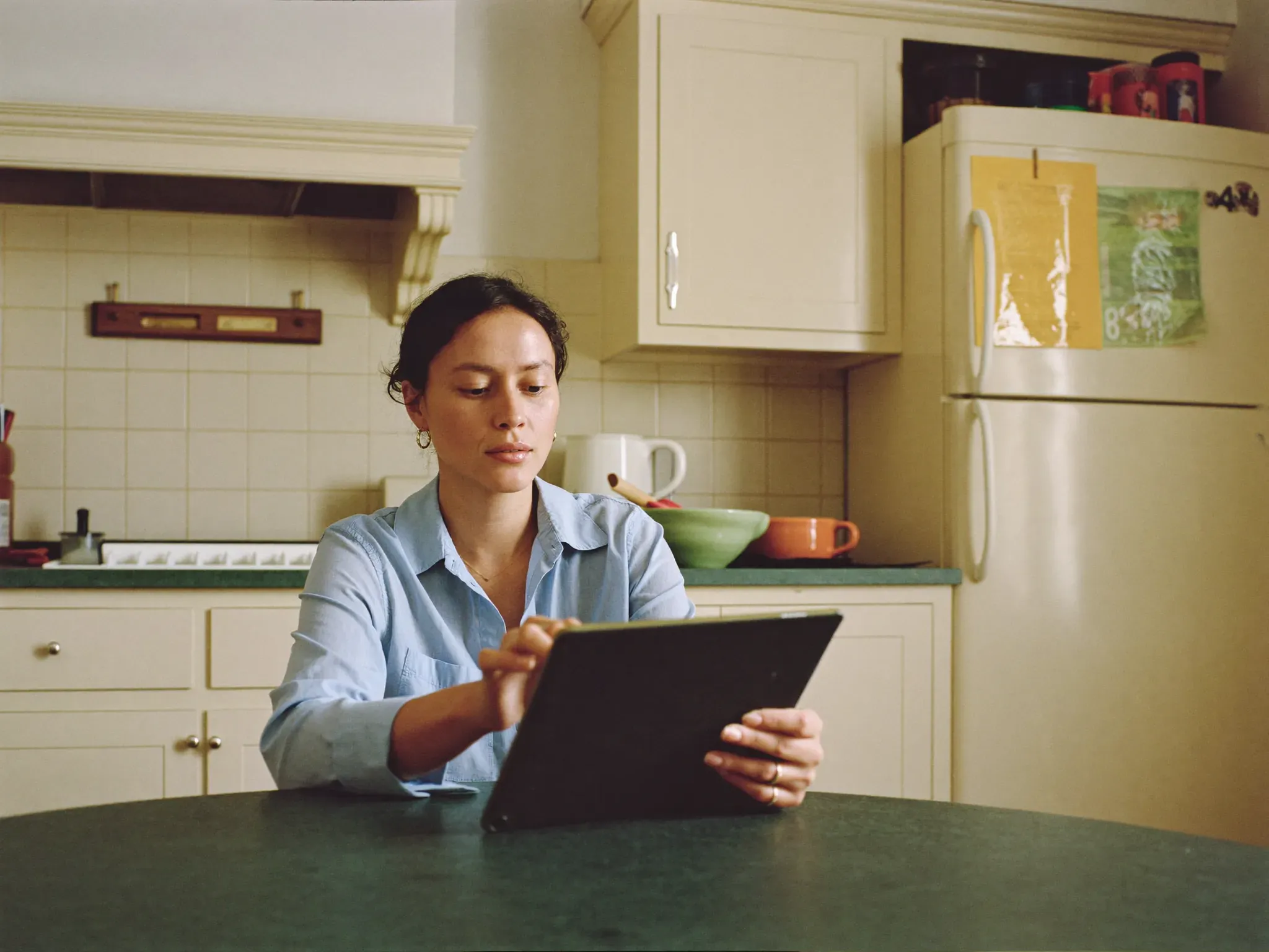 Adult browsing treatment options on a tablet at a kitchen table