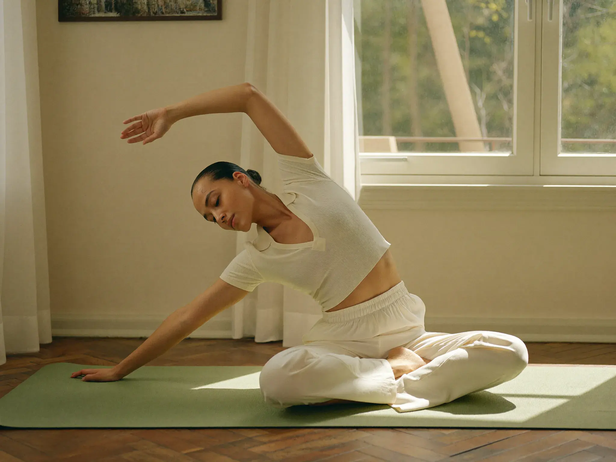 Adult doing a gentle morning stretch by a sunny window